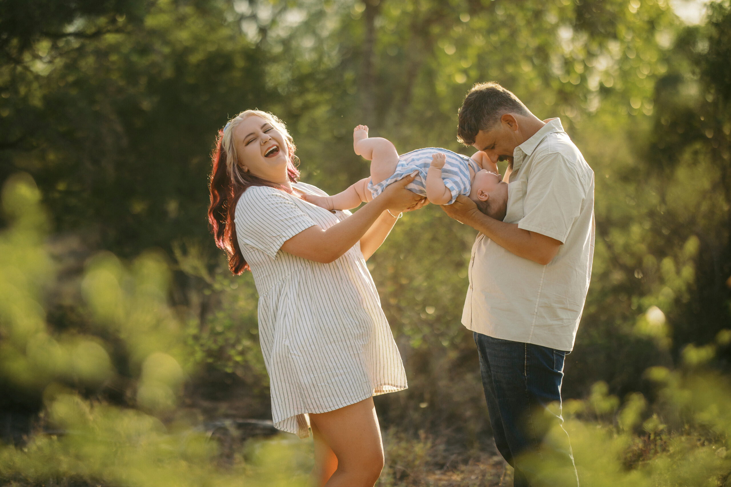 new born image of mum, dad and baby having fun on property near Blackwater for family photography
